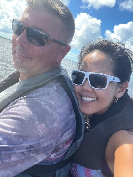 A person wearing a life jacket and a woman with sunglasses, both on a boat. 3