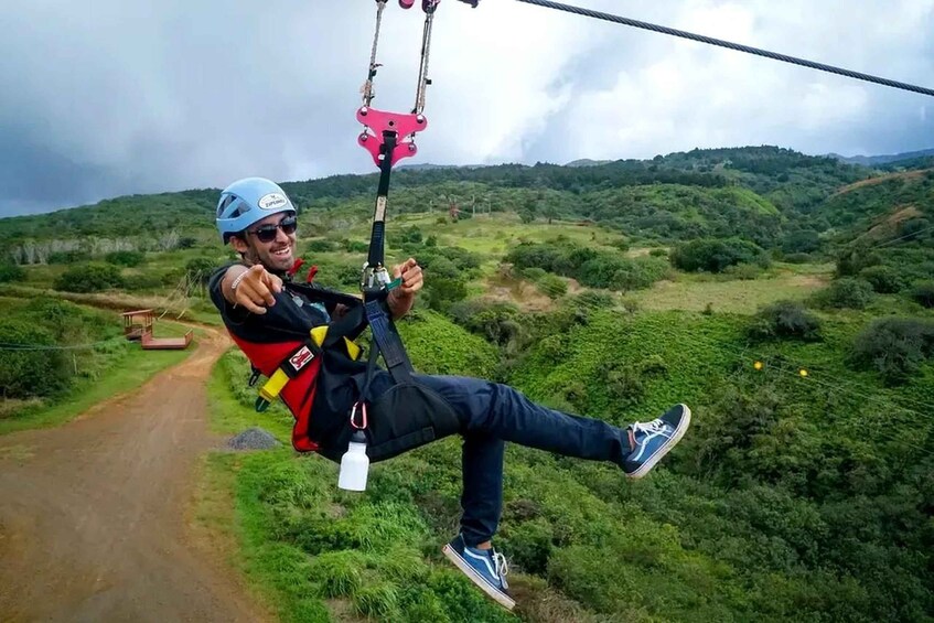 Una persona en tirolesa, usando casco y arnés, con un paisaje pintoresco al fondo. 5