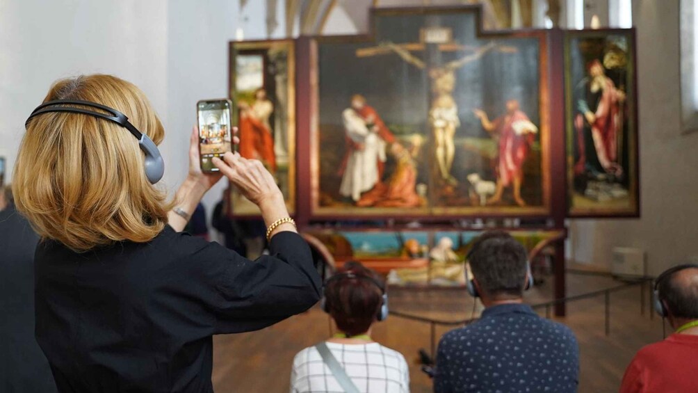 A person taking a photo of a painting in a museum. 1