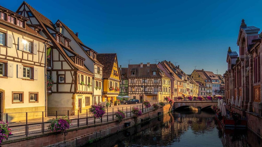 A canal with traditional European architecture, a bridge, and a clear sky. 4