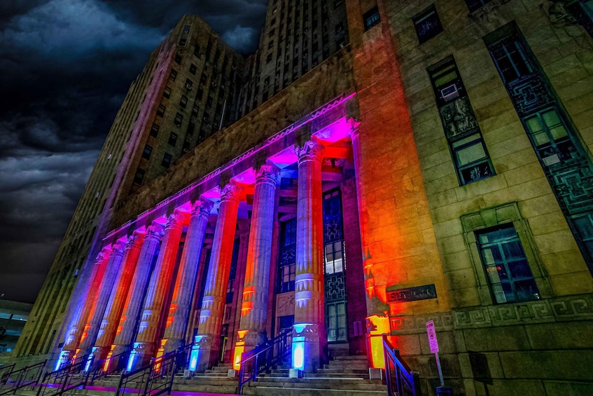 A building with illuminated columns and a staircase. 2