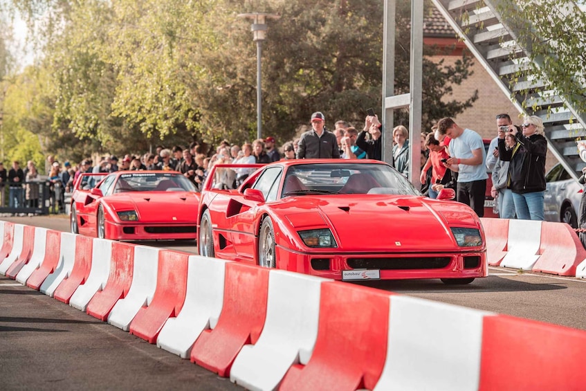 A red sports car parade with spectators. 1
