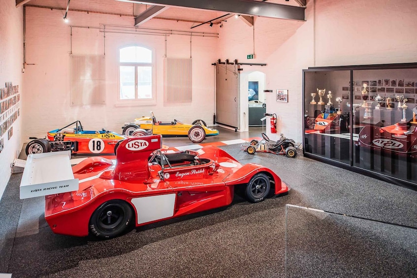 A racing car museum with vintage race cars and trophies. 2
