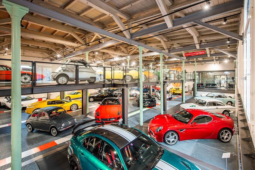 A multi-level car showroom with various sports cars on display. 5
