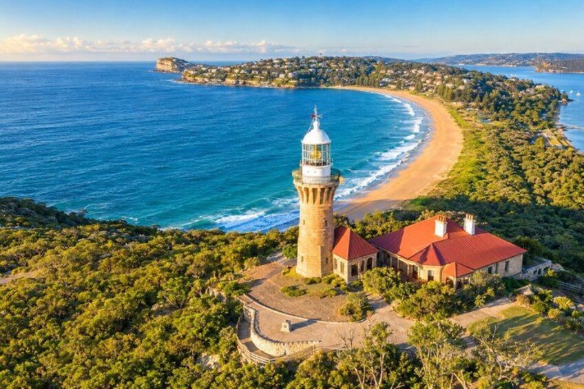 A coastal landscape with a lighthouse, beach, and surrounding greenery. 1
