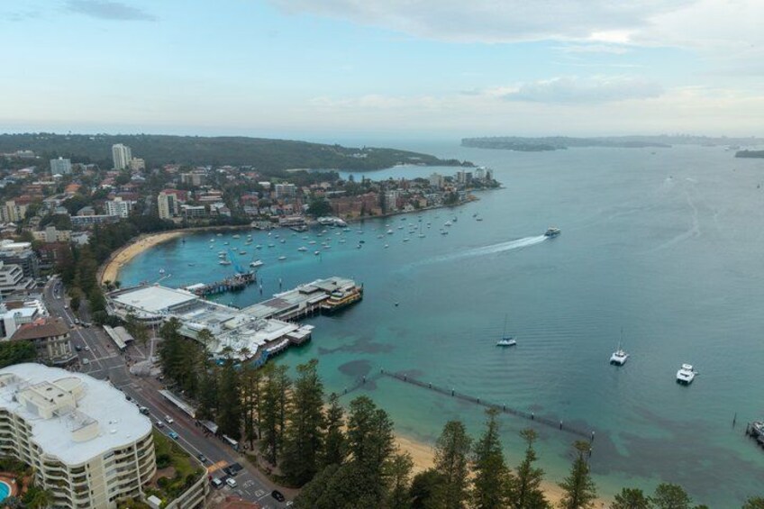 A coastal city with a marina, buildings, and a clear view of the sea. 4