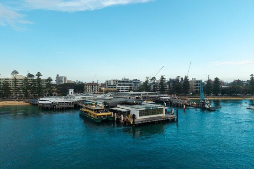 A waterfront area with a ferry terminal, boats, and buildings. 5