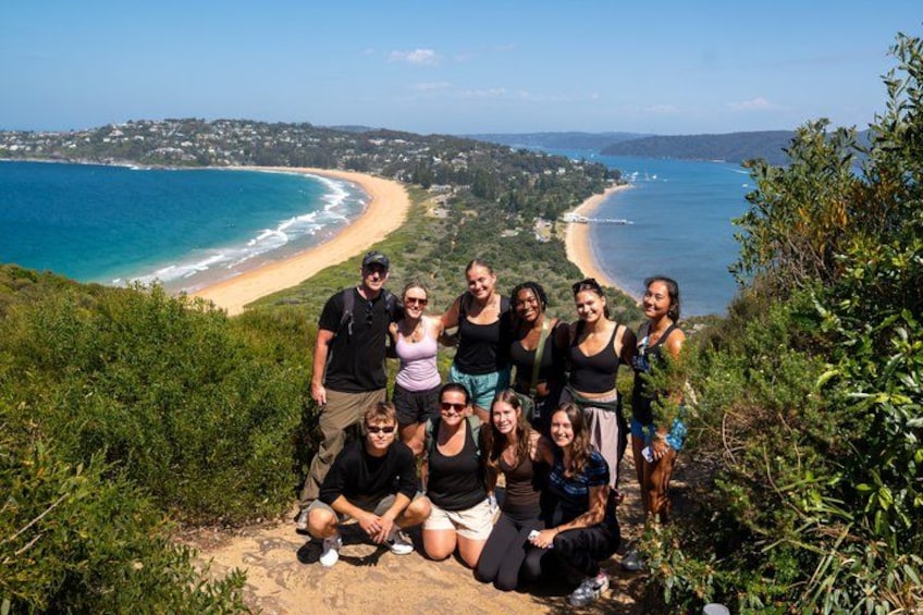 A group of people on a hill overlooking a beach with a clear view of the coastline. 5