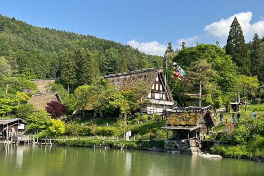 A traditional Japanese village by a lake with wooden houses and a large pagoda. 5