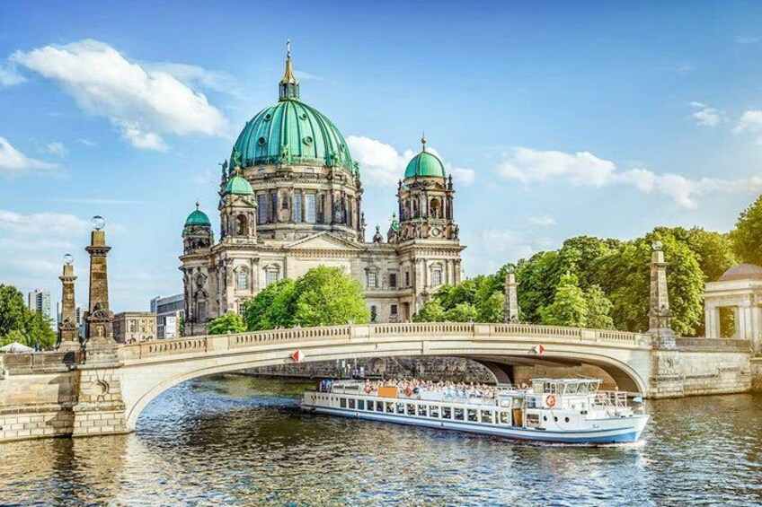 A historic building with a green dome, a bridge, and a river. 1