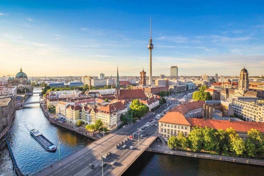 A cityscape with a river, a prominent tower, and historic buildings. 2
