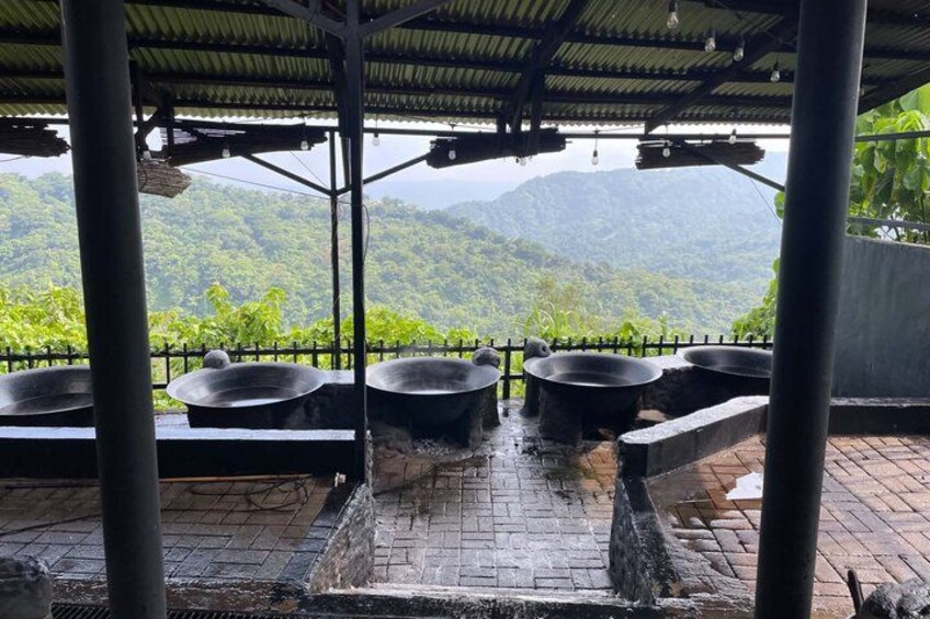 A covered outdoor area with large black pots and a water feature. 2