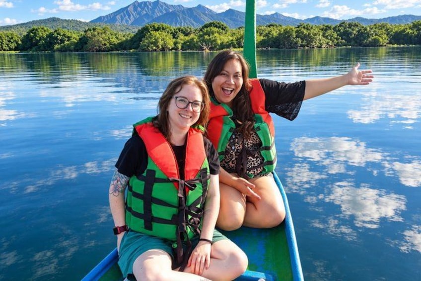 Two people in a boat wearing life jackets on a lake with mountains in the background. 5