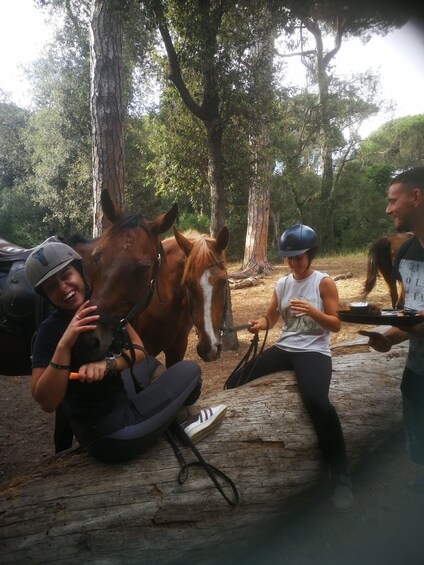 A person interacting with a horse in a wooded area. 2