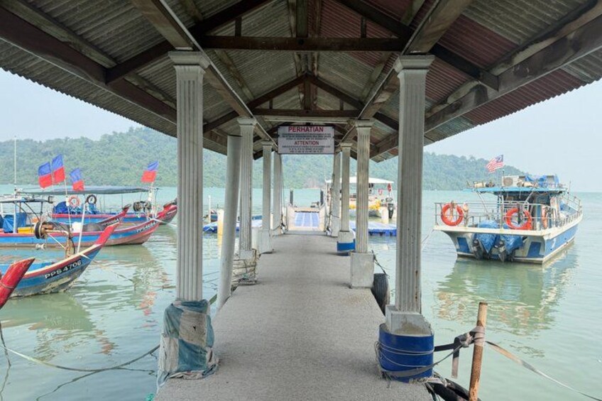 A pier with boats docked, a covered walkway, and a sign indicating 'PERHATIAN ATTENTION'. 2