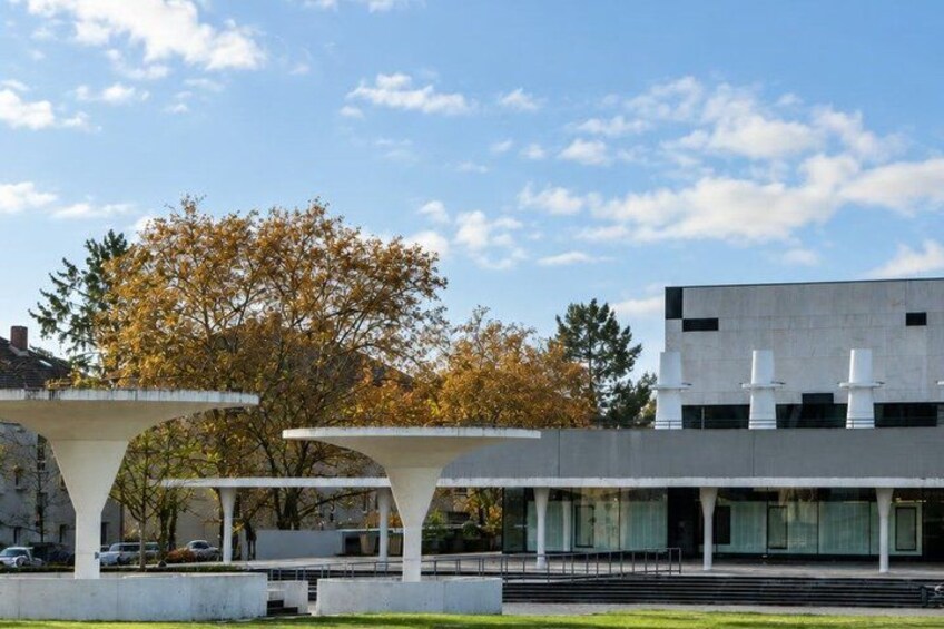 A modern building with a flat roof, large windows, and a white facade. 3