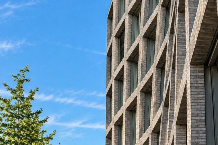 A modern building with a unique facade featuring diagonal lines and rectangular windows. 3