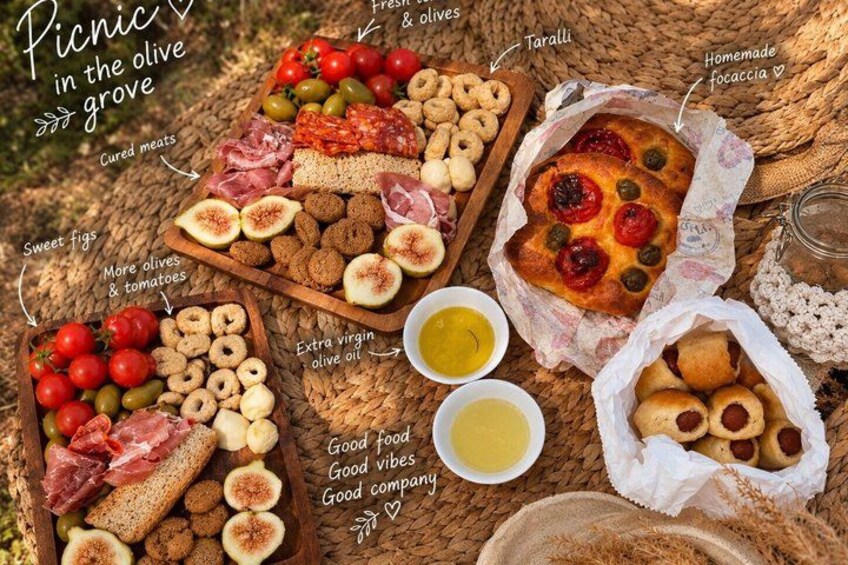 An outdoor picnic with various food items like cured meats, olives, and homemade focaccia. 2