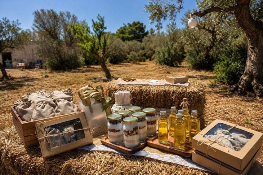 A rustic outdoor setting with a wooden crate, jars of honey, and a box of honeycomb. 5