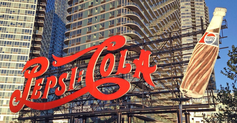 Un gran letrero de Pepsi Cola con una botella en un edificio. 4