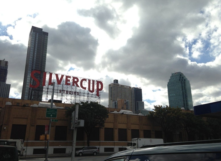 Un paisaje urbano con un cartel llamativo de 'SILVERCUP', un edificio moderno y un cielo nublado. 5