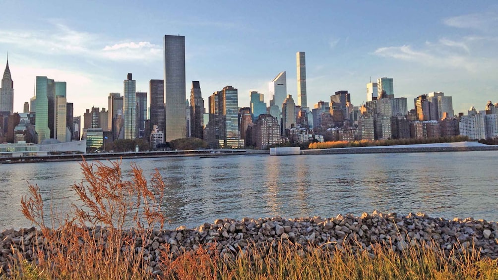 Un horizonte urbano con rascacielos modernos, un río y follaje otoñal. 1