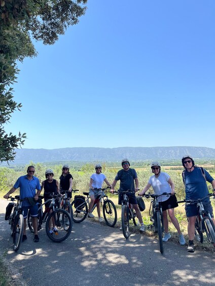 A group of people on bicycles in a natural landscape with mountains in the background. 3