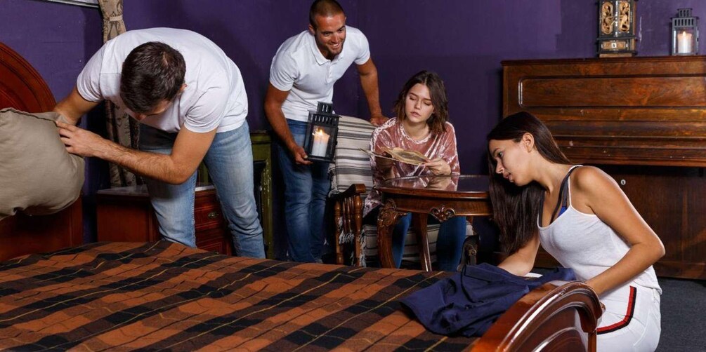 Una habitación con cama, cómoda de madera y una mesa con vela. 4