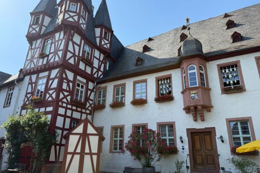 A traditional half-timbered building with a tower, multiple windows, and a door. 1
