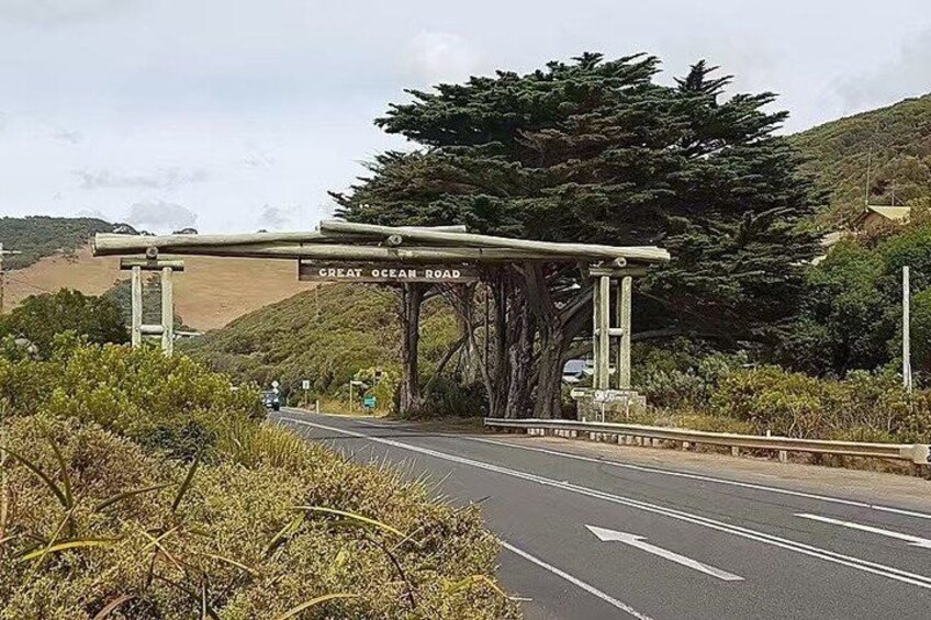 A road sign for Great Ocean Road, a road with multiple lanes, and a guardrail. 5