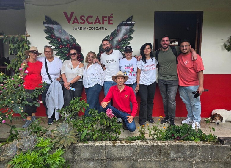 A group of people posing in front of a building with a sign reading 'Vascafé Jardin-Colombia.' 5