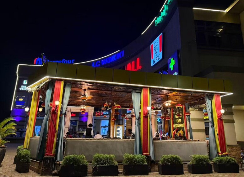 Un restaurante KFC con letreros coloridos y un área de estar al aire libre techada. 3