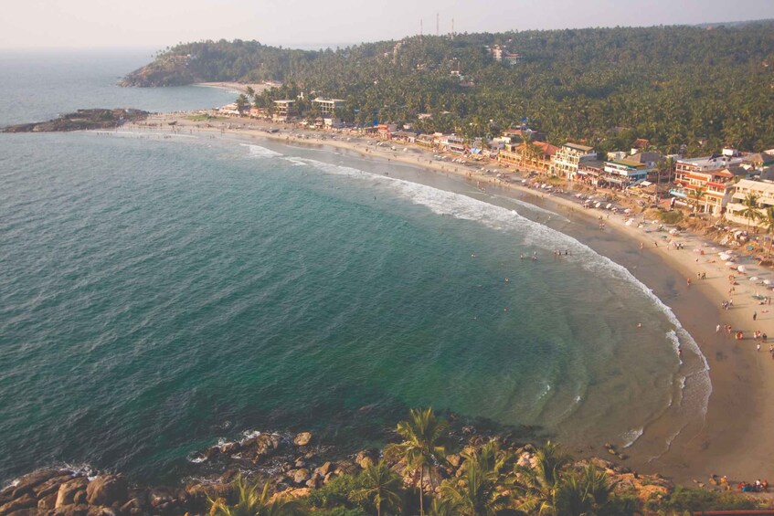 Un pueblo costero con playa, aguas azul turquesa y un telón de fondo montañoso. 4