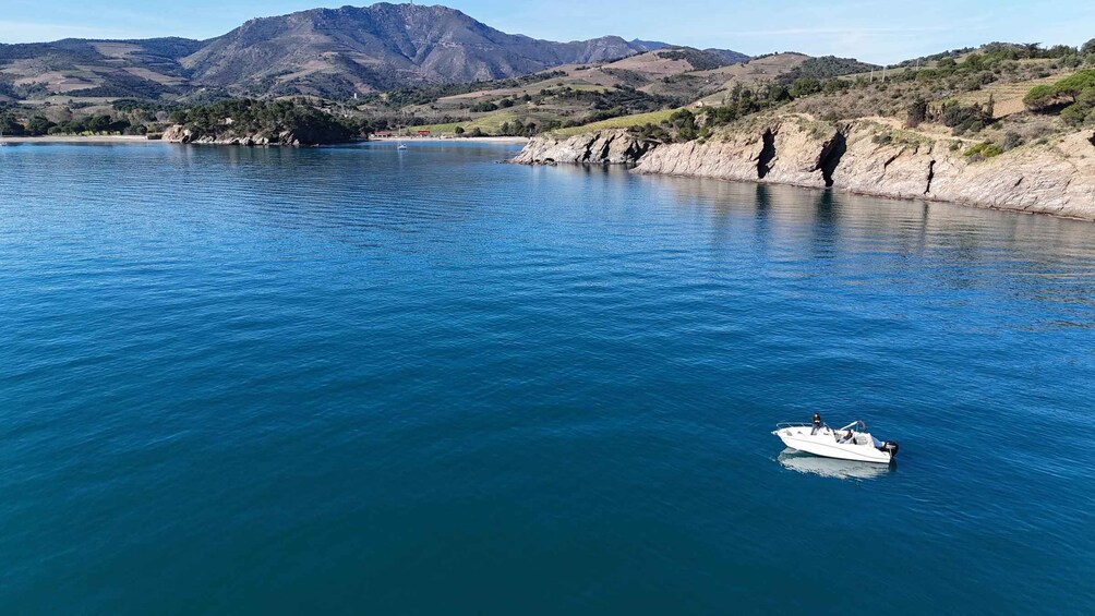 Un barco en un lago azul y tranquilo rodeado de colinas. 1