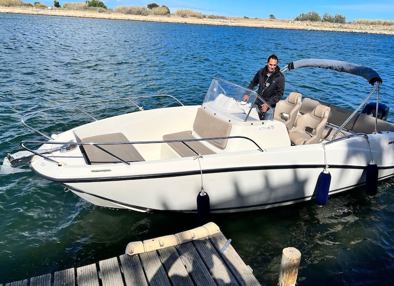 Un barco motor blanco con toldo, amarrado a un muelle de madera. 3