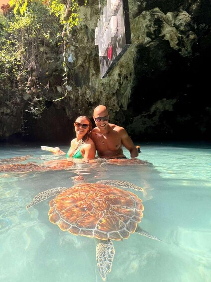 Una pareja en una piscina cristalina con una tortuga marina. 1
