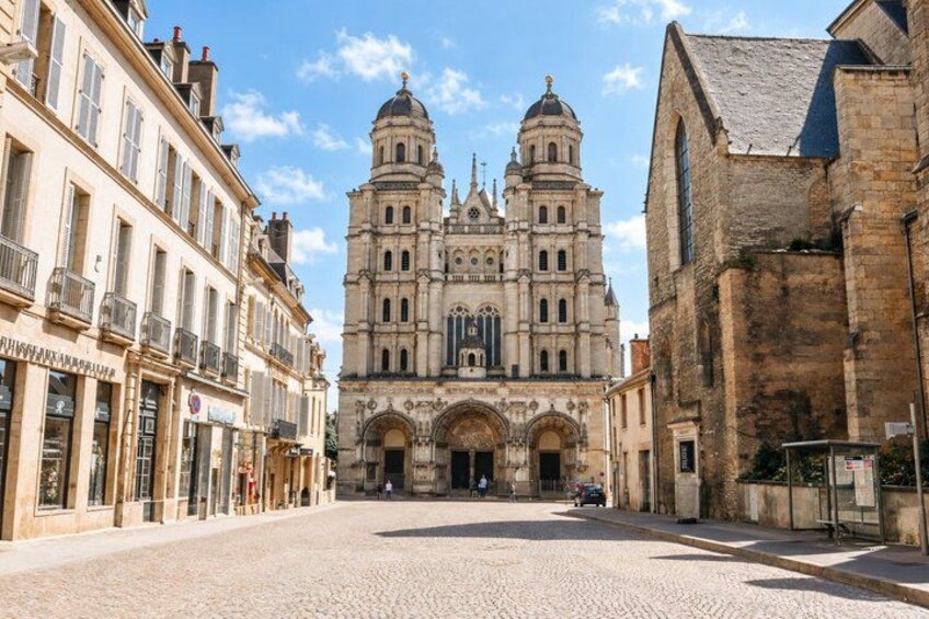 A cobblestone street leading to a historic cathedral with two domes. 4