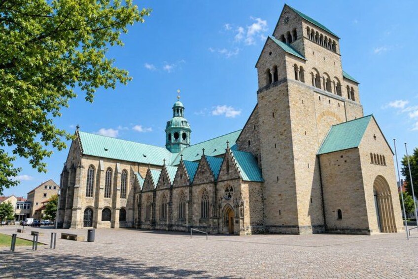A historic church with a tall tower and a green roof. 3