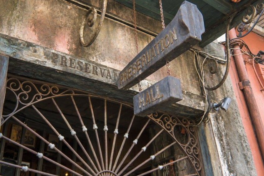 A weathered metal sign with the words 'PRESERVATION HALL' and a decorative metal gate. 2