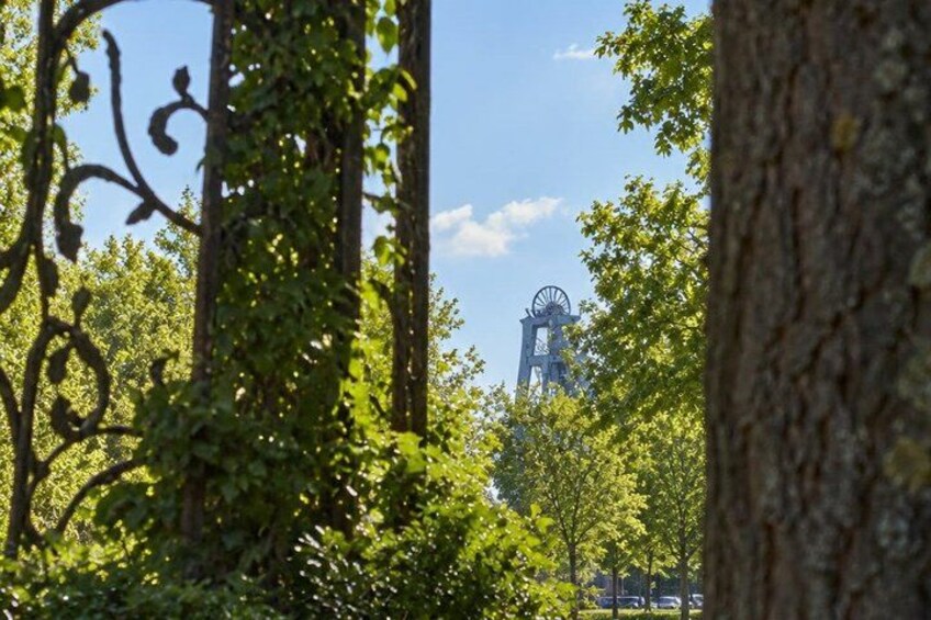 A windmill in a forested area with trees and a clear sky. 4