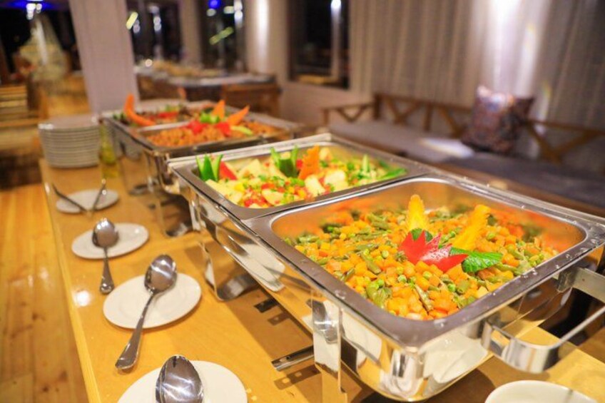 A buffet with various food items in metal serving trays. 5