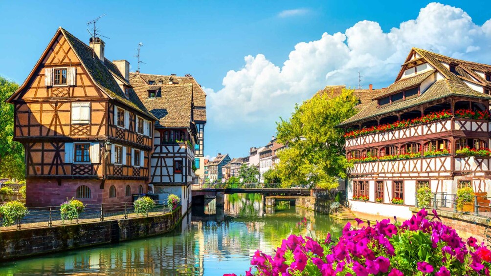 A picturesque European town with half-timbered houses, a calm river, and vibrant flowers. 3
