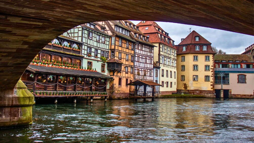 A river with traditional half-timbered buildings and a wooden bridge. 5