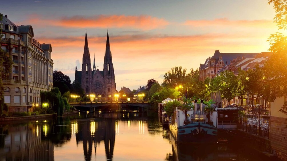 A cathedral with twin spires, a river reflecting the buildings, and a bridge with lights. 2
