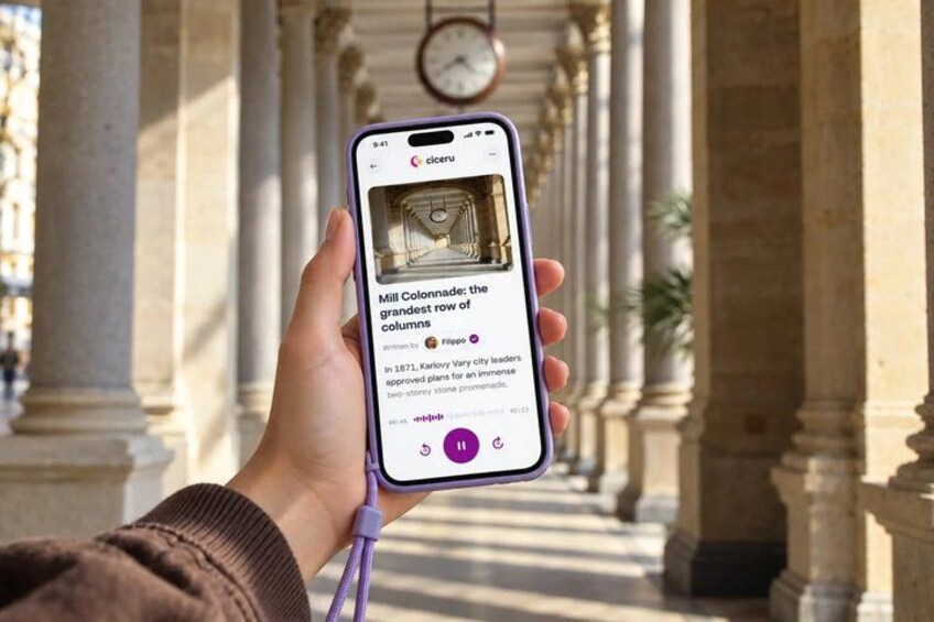 A person holding a smartphone with a historical building in the background. 1