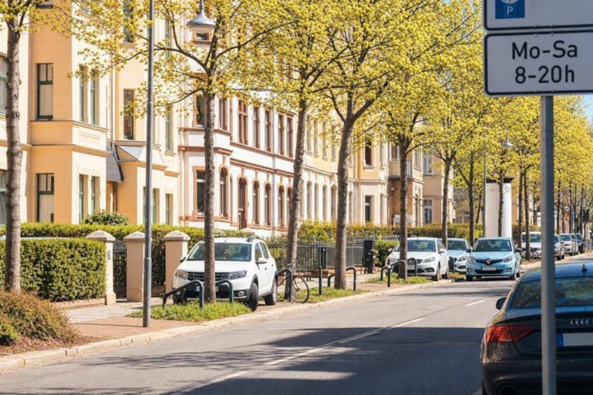 A residential street with parked cars, a bicycle, and a parking sign indicating Mo-Sa 8-20h. 5