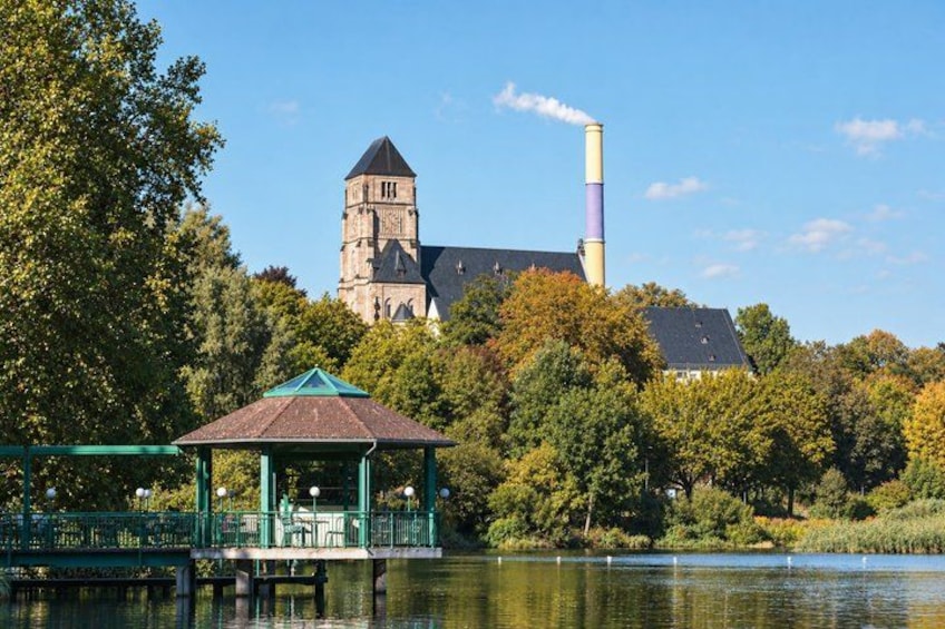 A gazebo by a lake, a church with a tower, and a chimney. 4