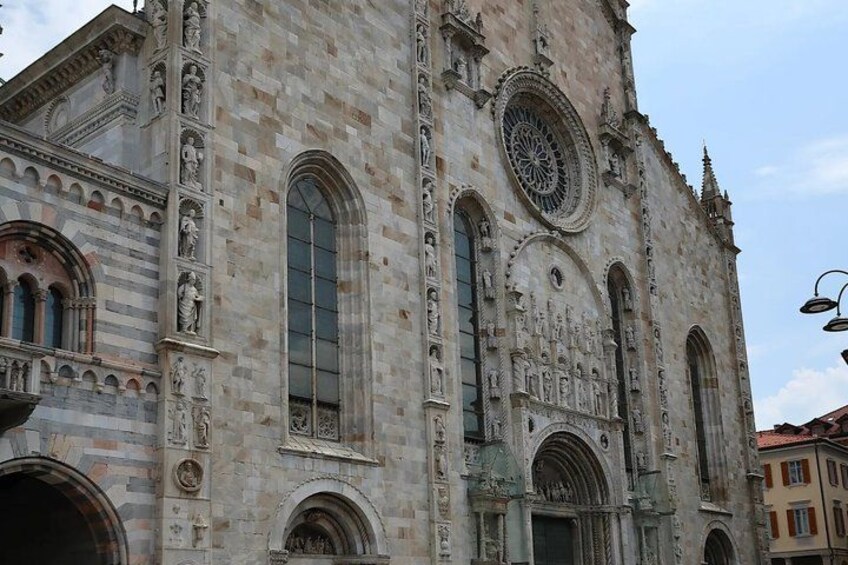 A historic stone building with arched windows and intricate carvings. 5