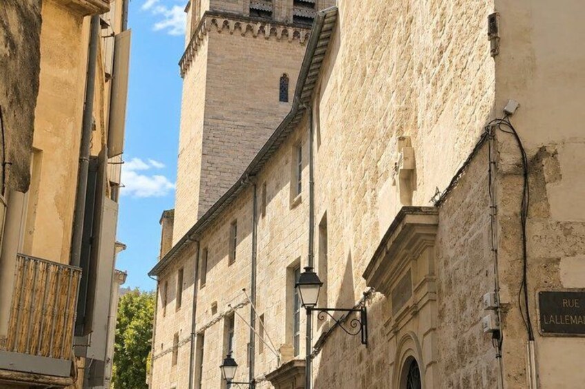 A historic building with a tower, a street lamp, and a sign reading 'RUE LALLEMAND'. 3