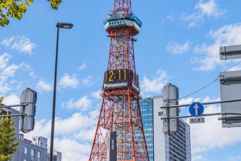 A red tower with a digital clock displaying '2:11' and the word 'Panasonic' on it. 2